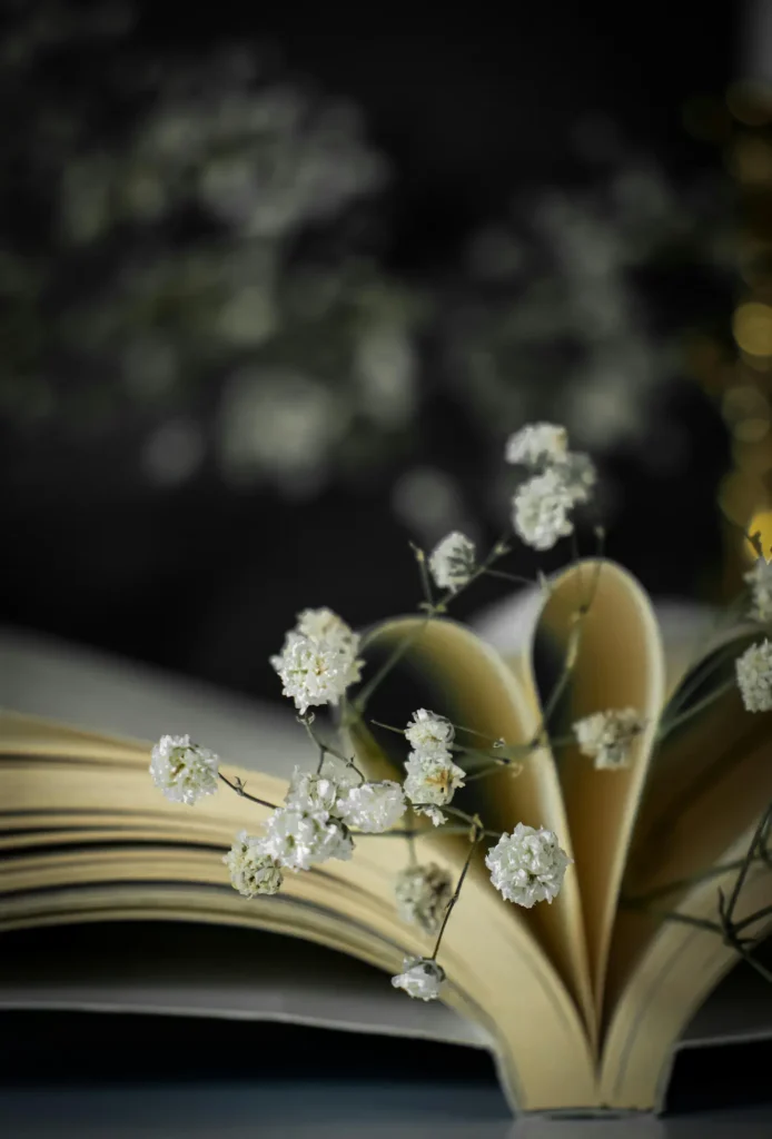 En öppen bok där boksidorna har formats till ett hjärta, omgiven av blommor. En symbol för den passion och de känslor som ryms när man ska skriva en biografi om sitt liv.