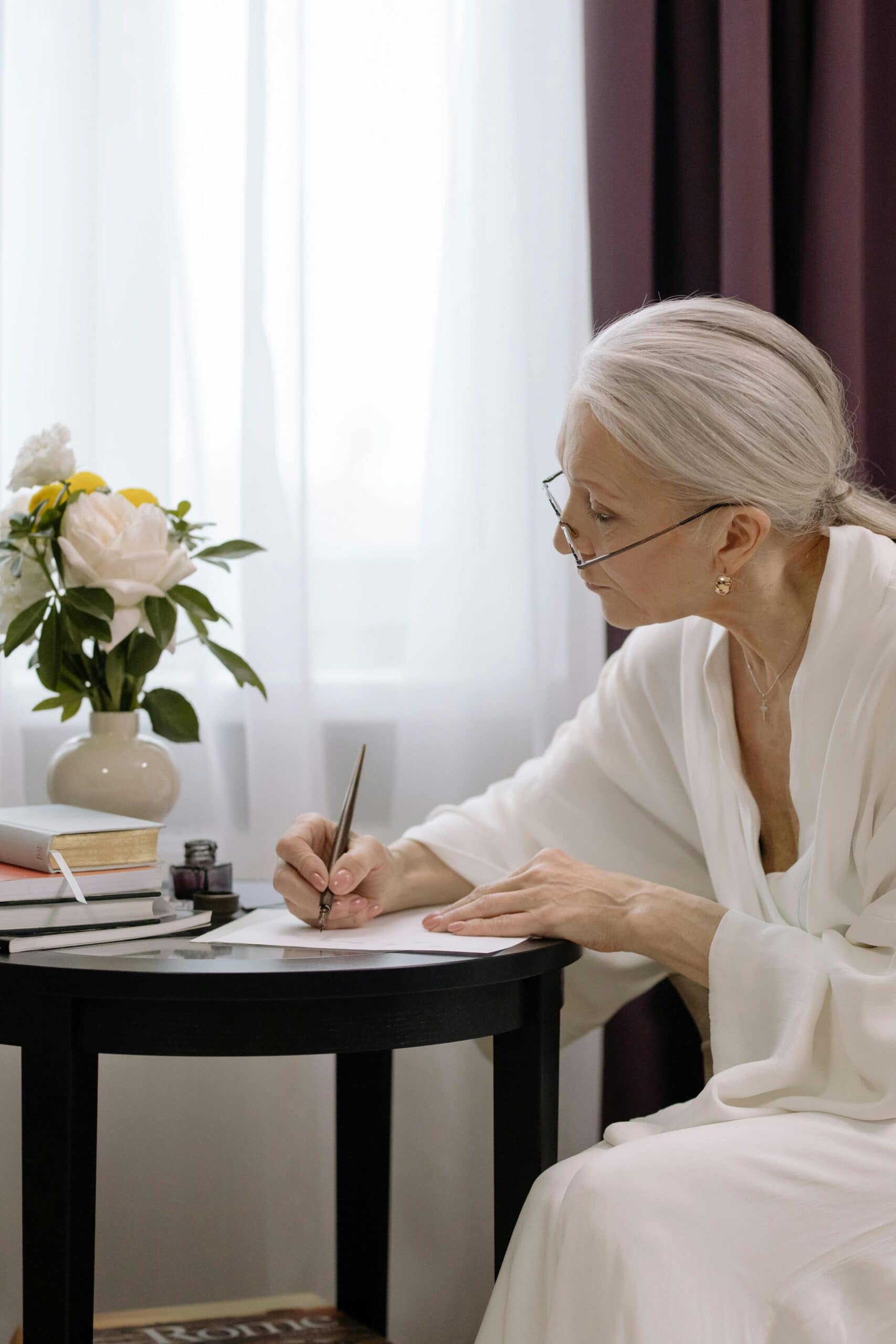 En kvinna som sitter fokuserat och arbetar med att strukturera sin självbiografi i en anteckningsbok.